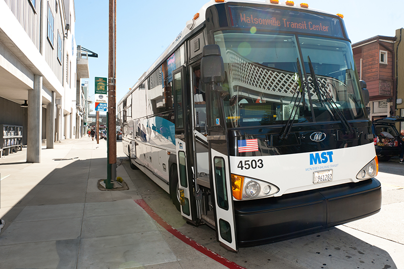 A front-end view of a public transportation bus parked in front of the Aquarium