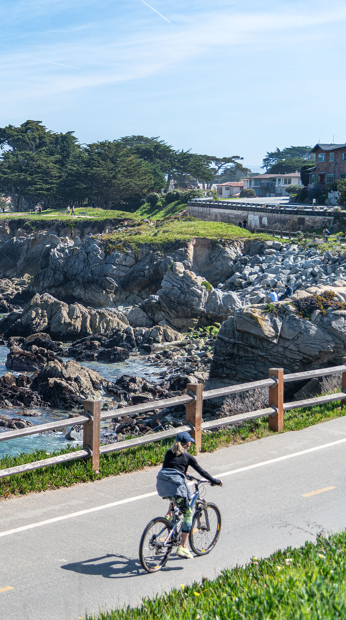 A person riding their bike on the coastline along the recreation trail in Pacific Grove, CA