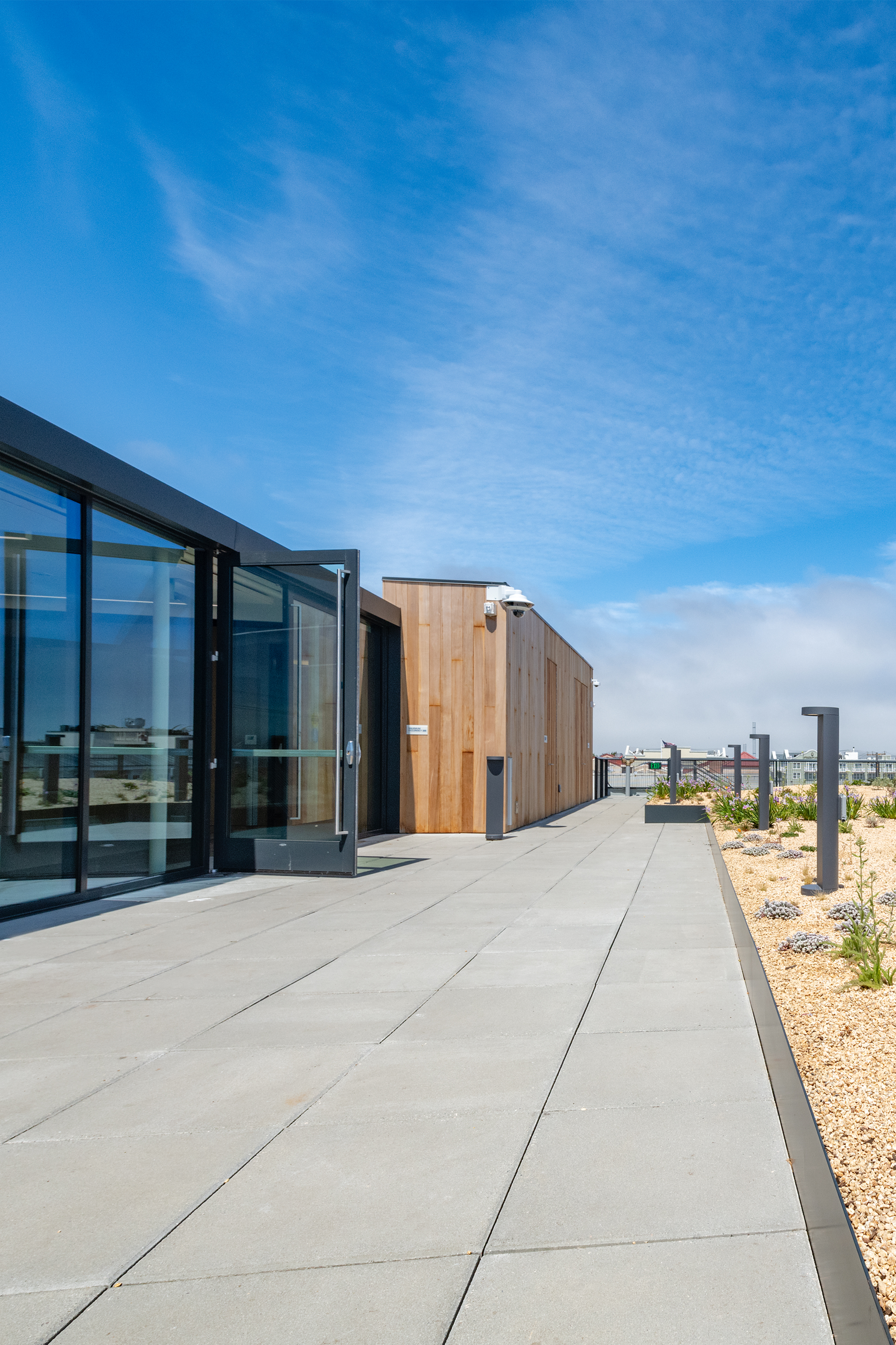 The sunny rooftop terrace of the Aquarium's Bechtel building featuring large glass windows and a garden under a clear blue sky