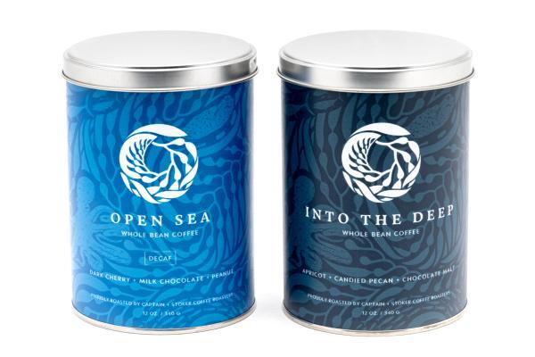 Two branded Monterey Bay Aquarium and Captain + Stoker coffee cans with a white background
