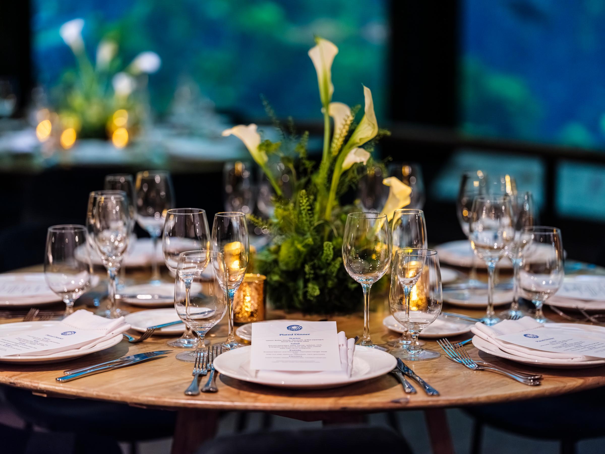 Close up of an elegant dinner table setting for an evening event in the Kelp Forest exhibit of the Monterey Bay Aquarium