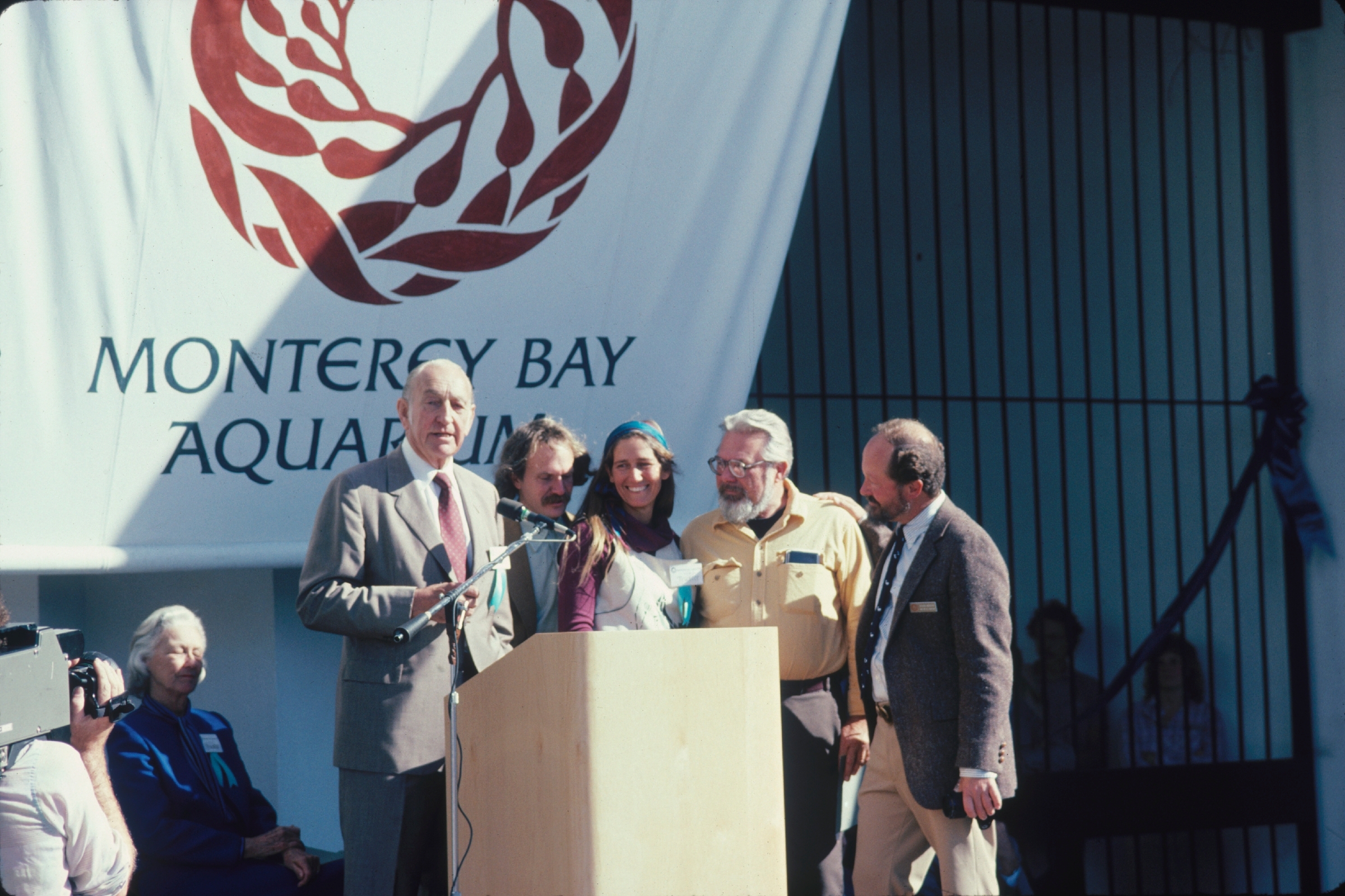 David Packard and other founders standing at podium on opening day of the Aquarium