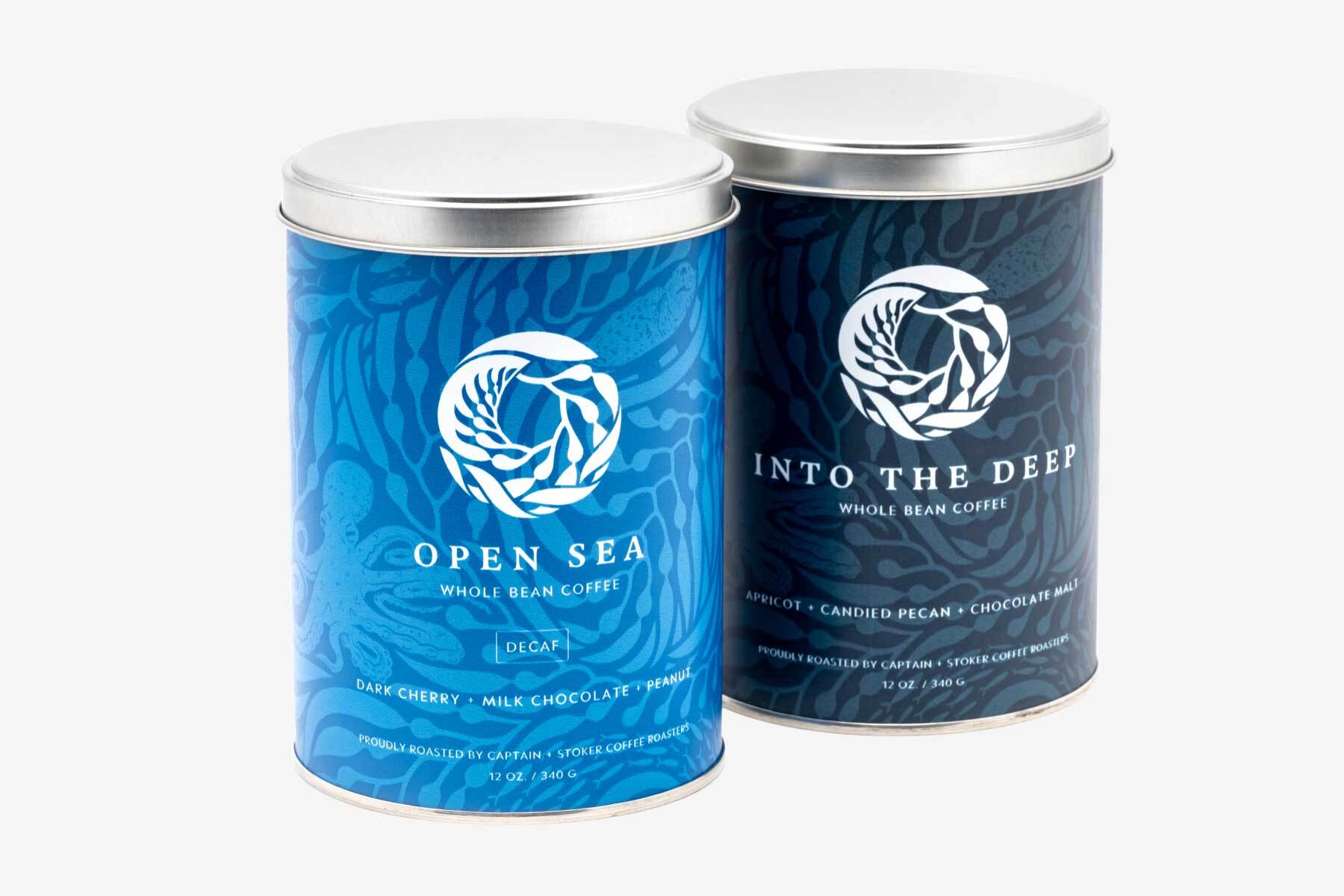 Coffee cans one light blue with Open Sea and the othe dark blue called Into the Deep collaboration with Captain Stoker coffee