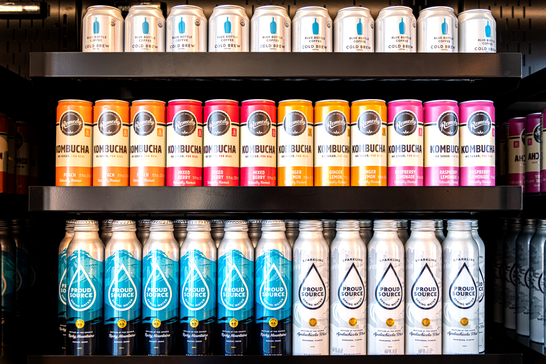Shelves stocked with canned beverages including kombucha, cold brew coffee, and sparkling water in a retail display