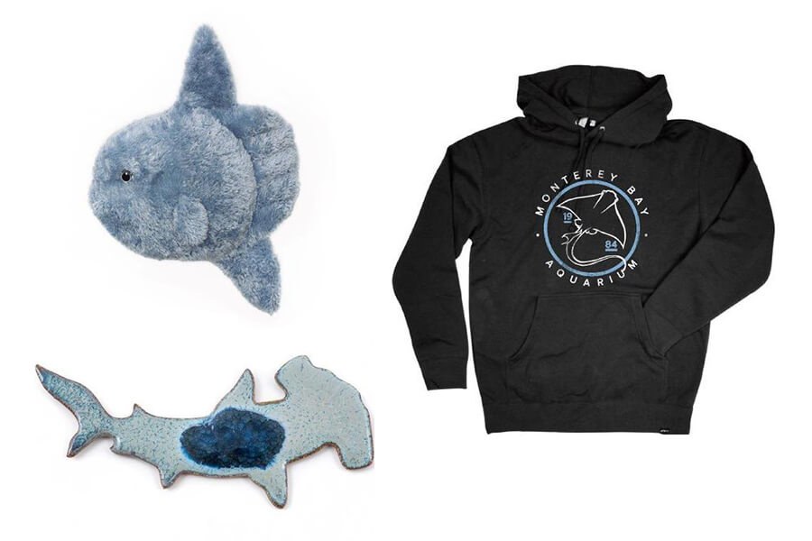 Collage of products from Open Sea collection, featuring a hooded sweatshirt with ray, mola plush toy, and hammerhead shark trinket.