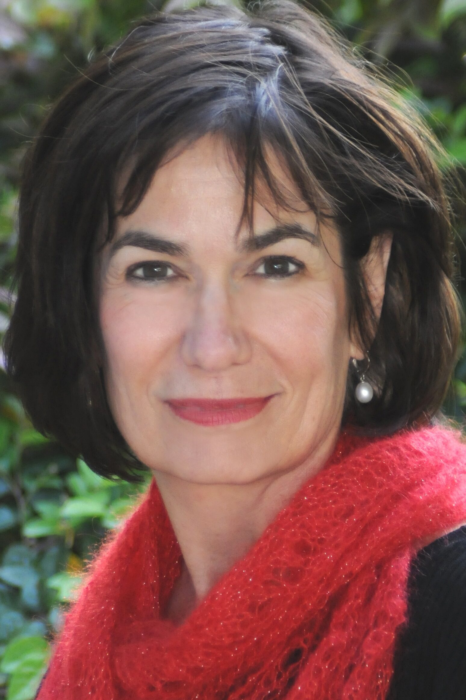 Leslie Davenport faces the camera with a slight smile. She is wearing a red scarf over a black top.