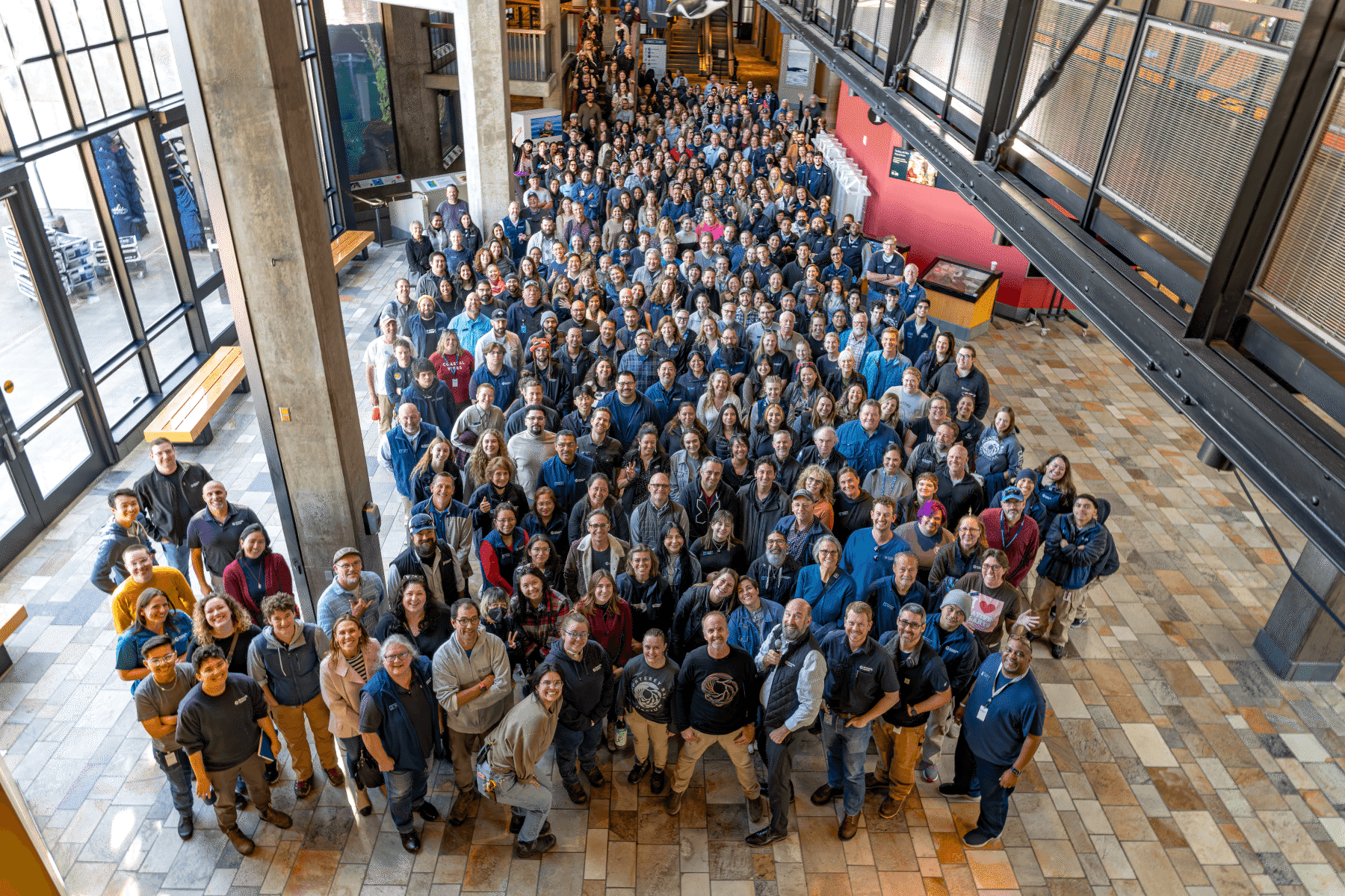 Overhead view of hundreds of Aquarium staff gathered together for a group photo inside the Aquarium