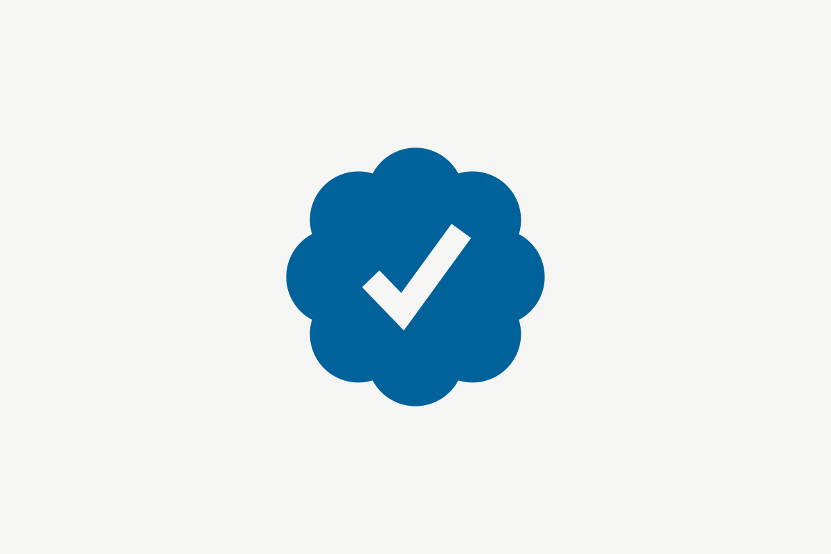 Blue circular badge with a scalloped edge containing a white checkmark in the center.
