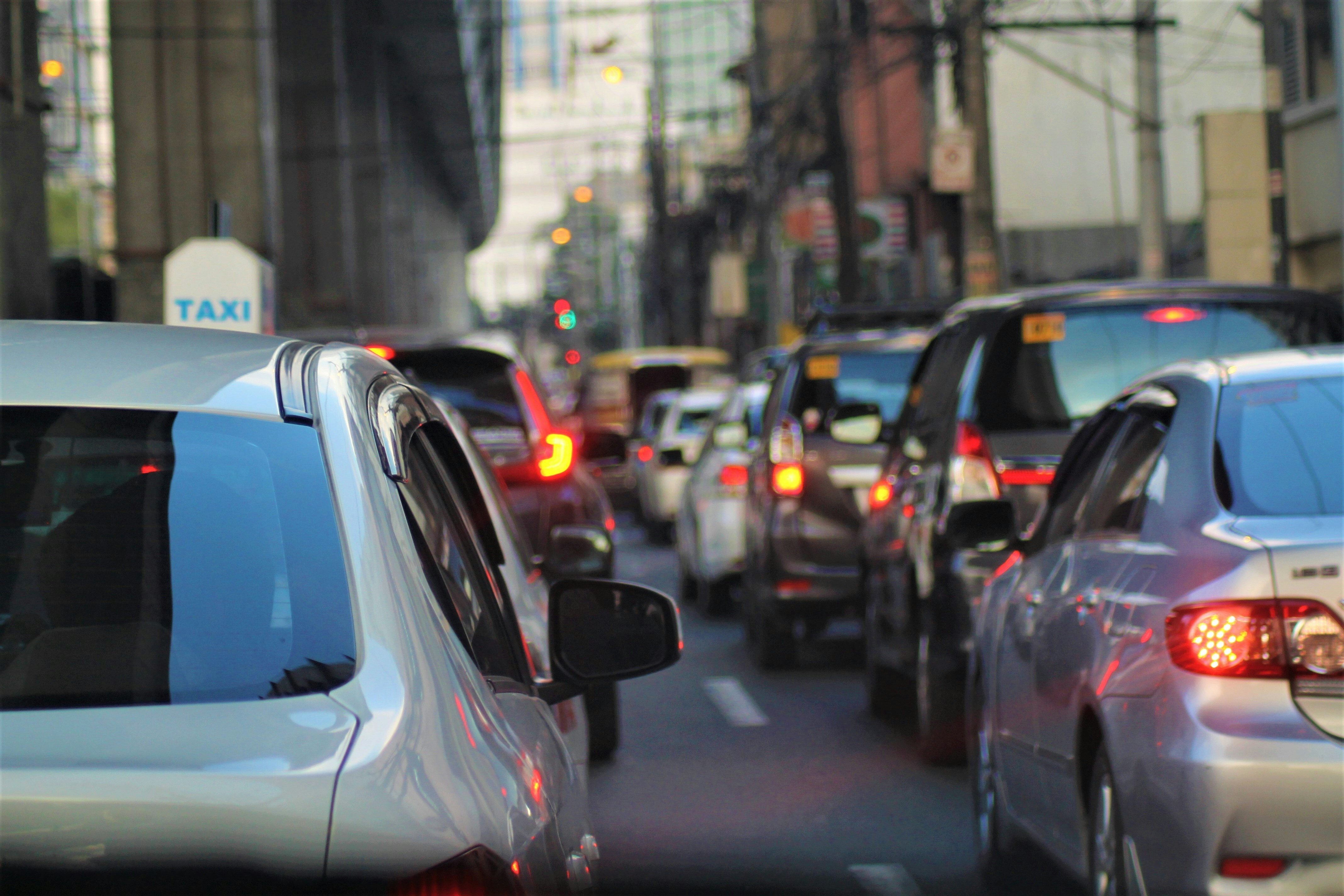 Heavy urban traffic jam with cars stopped on a city street a taxi sign visible in the background