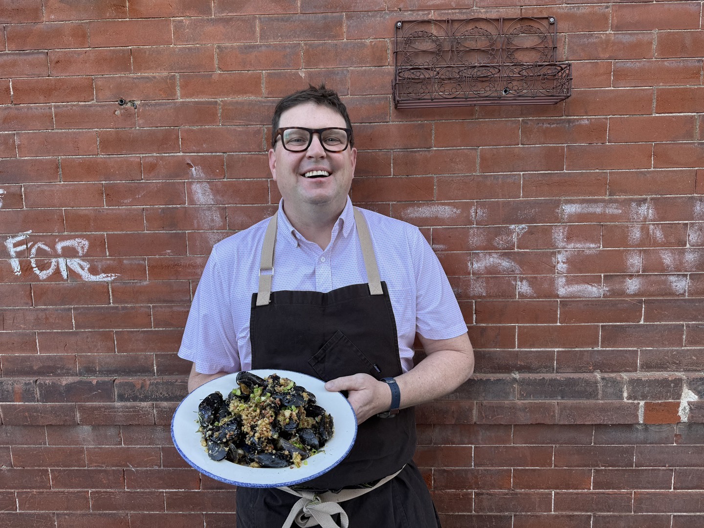 Chef Paul Reilly holds mussels a la plancha
