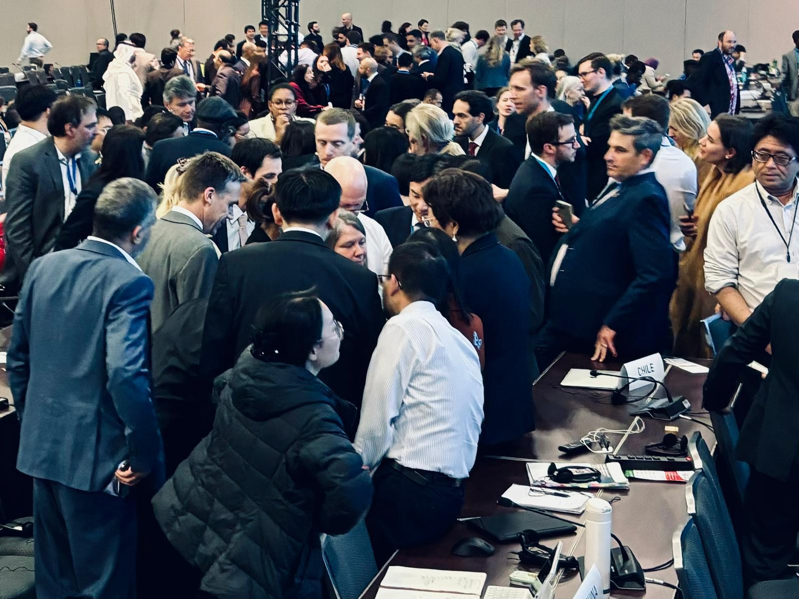 People crowd together in late-night plastic treaty negotiations