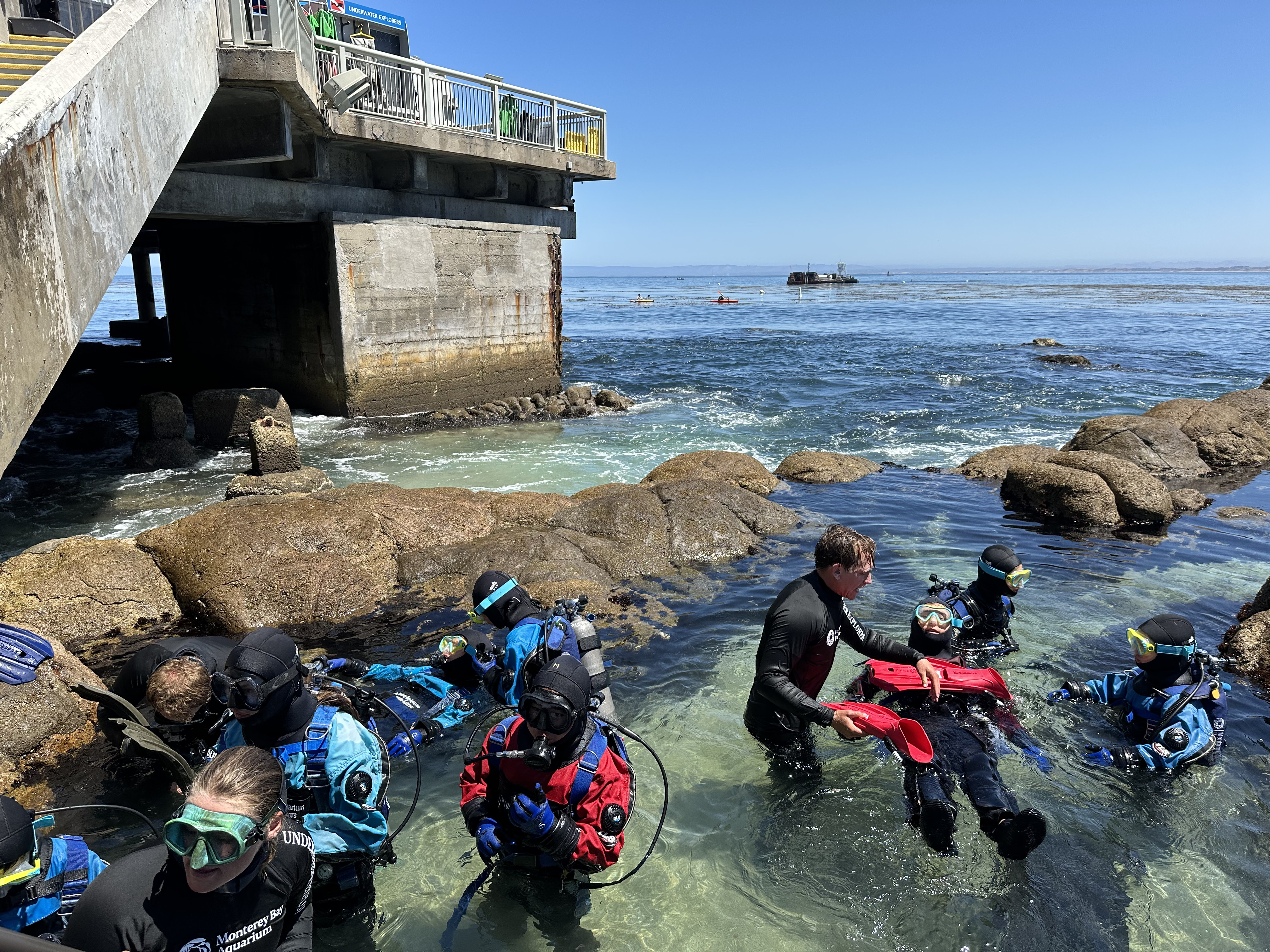 Underwater Explorers enter into the Great Tide Pool to begin their surface scuba dive with dive instructors.