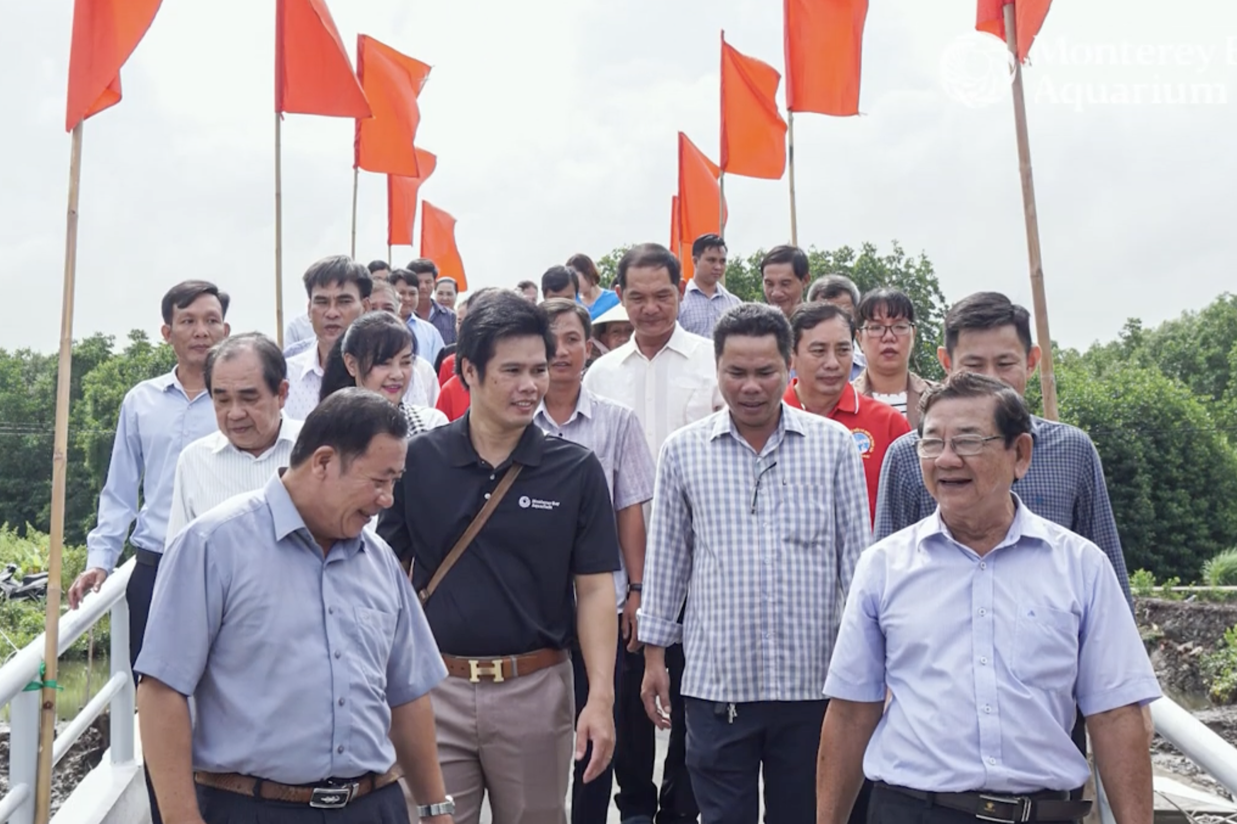 Do Vu Linh, Monterey Bay Aquarium global fellow and Vietnam program manager, walks with community members and shrimp farmers in Vietnam during a field visit.