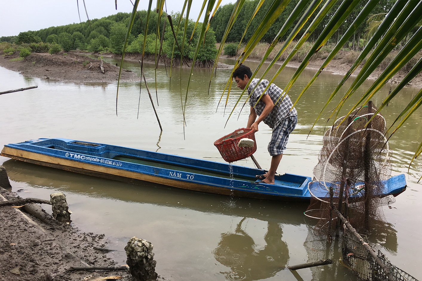 Small-scale black tiger shrimp farmer working from his boat in Vietnam.